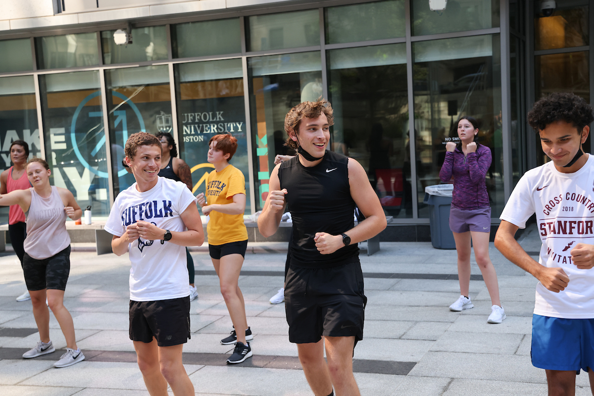 Suffolk student Nico exercises in a group class held on Roemer Plaza.