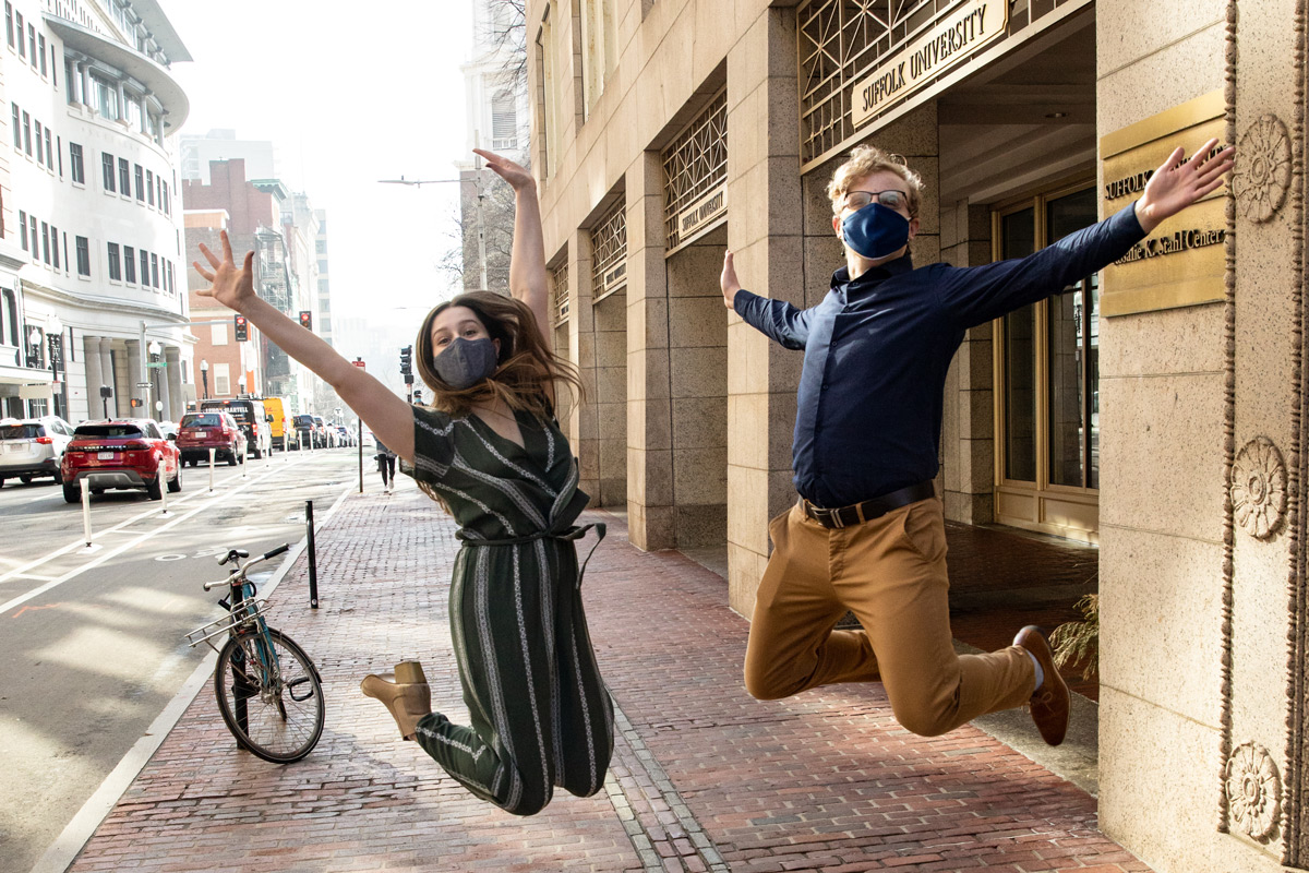 Suffolk students Morgan and Collin jump together on Tremont Street in downtown Boston.