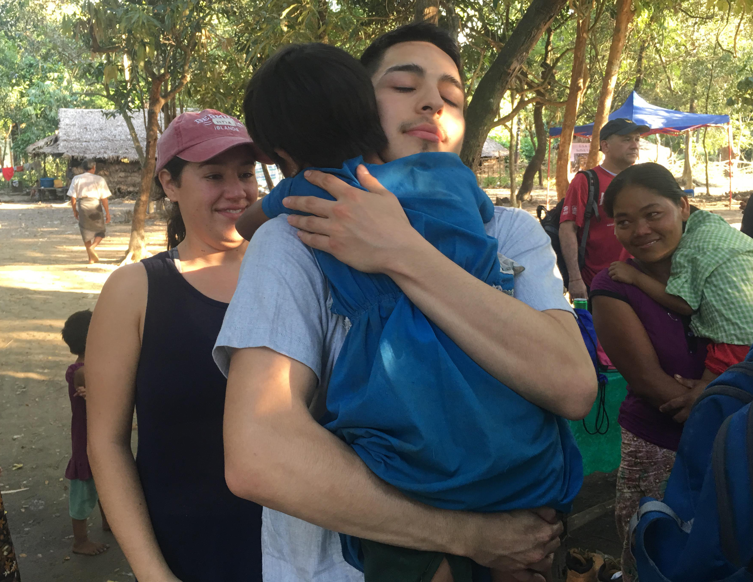 Suffolk student Kevin Luna-Torres holding a child in Myanmar following a week-long home build.