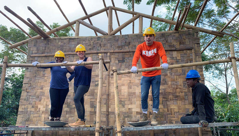 Suffolk students pause while constructing a habitat for humanity home in Myanmar