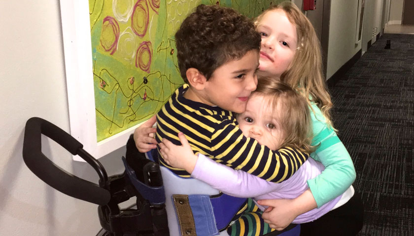 Three young children hug at Christopher's Haven