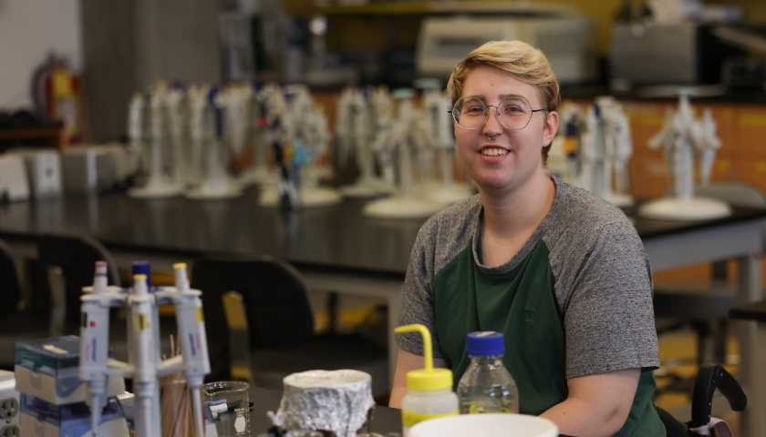 Skylar Rungren at a lab bench surrounded by equipment
