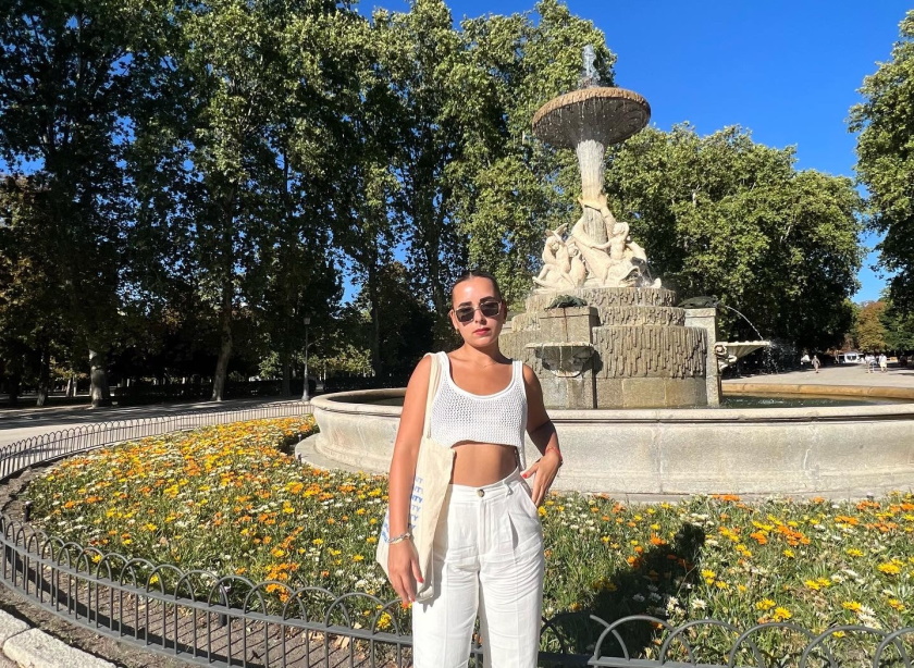 Lauren wears sunglasses as she stands in front of a fountain in Madrid