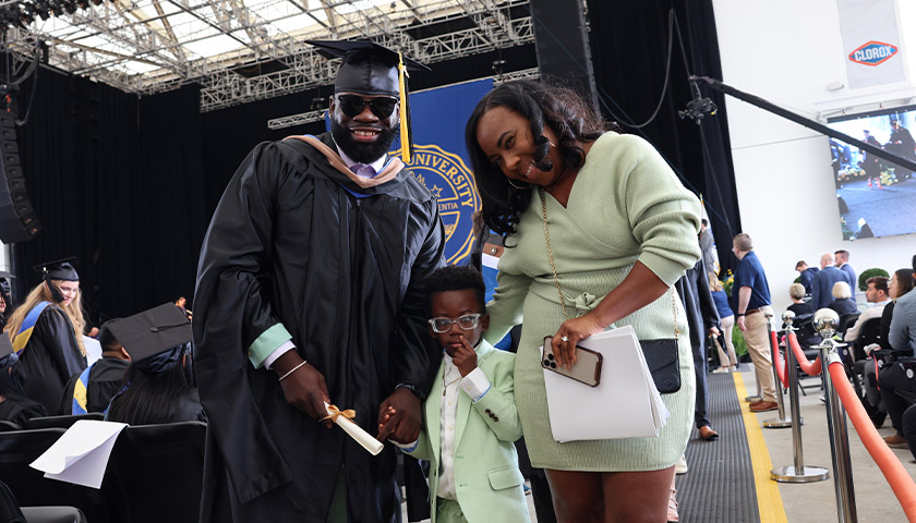 Kevin Barthelemy at his Suffolk Commencement with his wife and young son