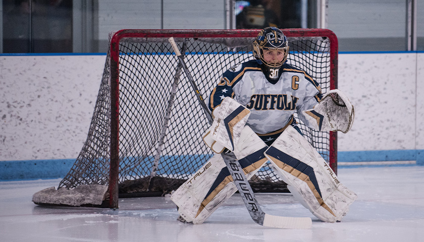 Suffolk women’s ice hockey goalie Lily O’Neil standing in the net ready to block a shot
