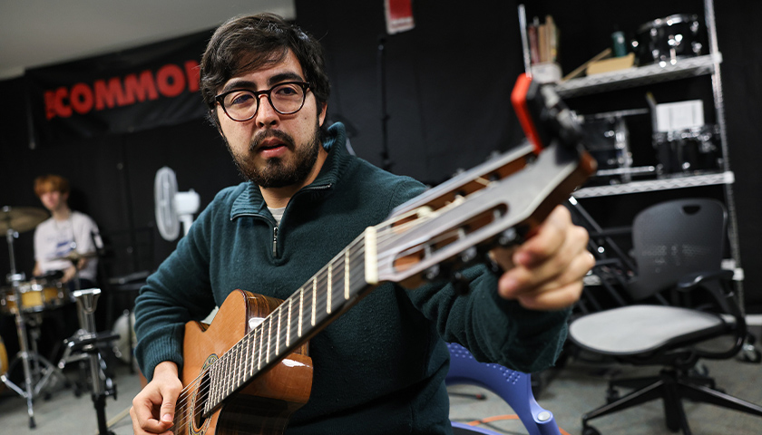 Andoreni Bustos tunes his acoustic guitar