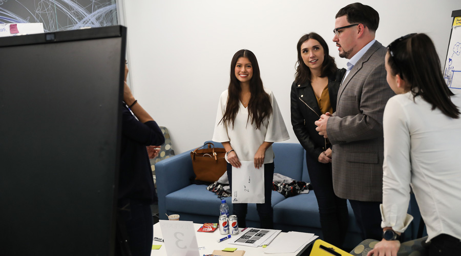 A group of Suffolk students meeting with an employer partner during a client presentation.