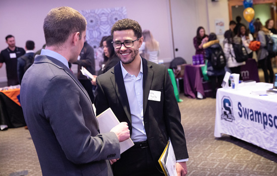 A Suffolk student networks at a careers event.