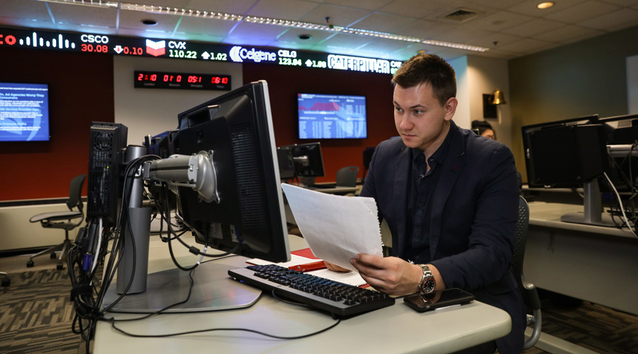 A Suffolk student sits at a finance terminal in the trading room.