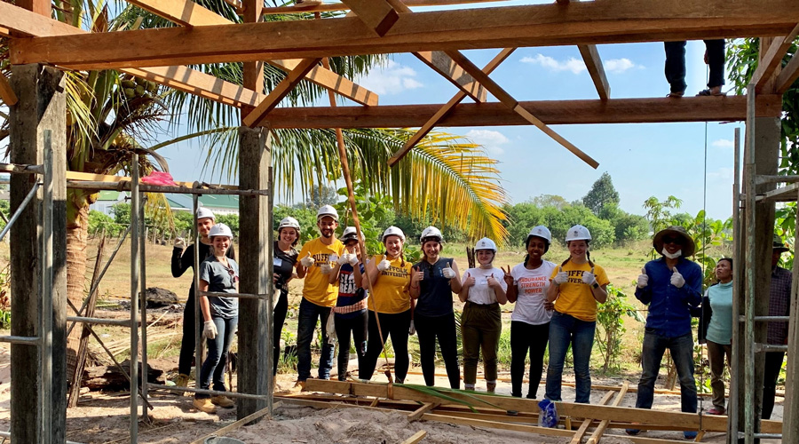 Suffolk students pose for a photo while building a home in Cambodia.