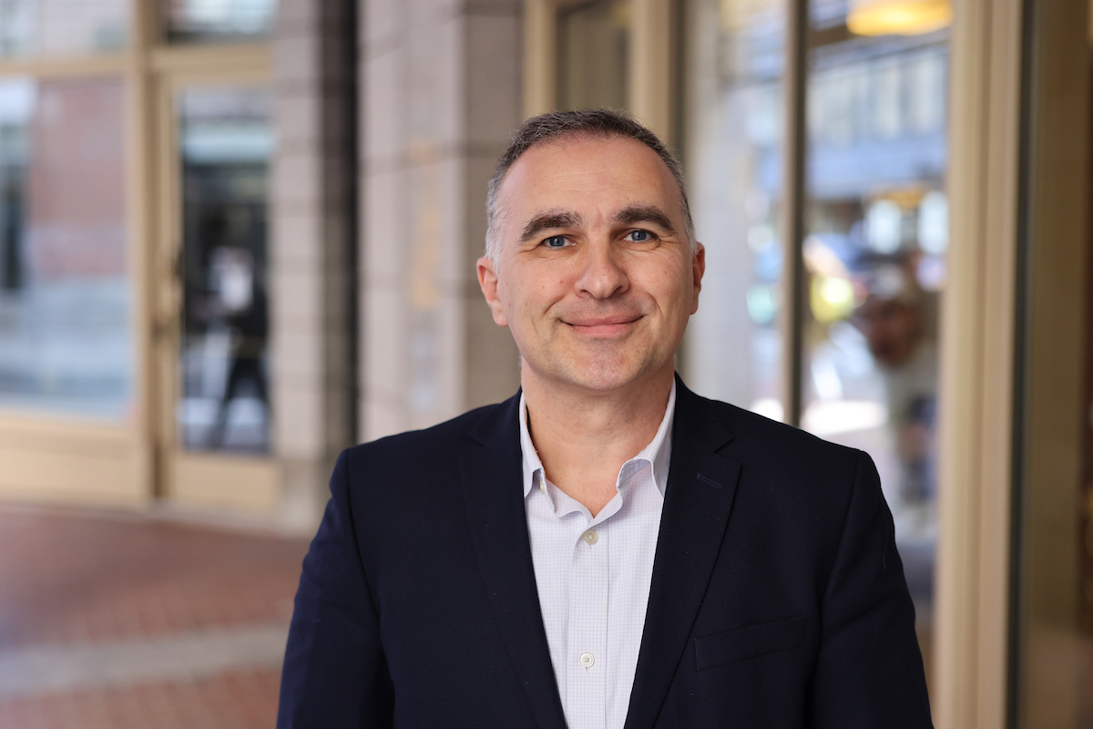 Boris Lazic outside, smiling with blue jacket and white collared shirt