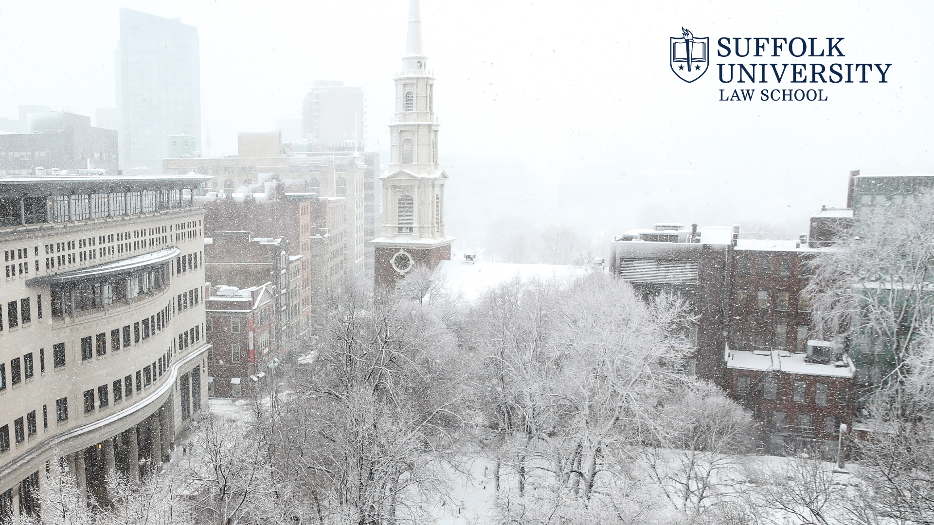 View of Sargent Hall and Tremont Street during a snow storm with the Suffolk Law logo in the top corner
