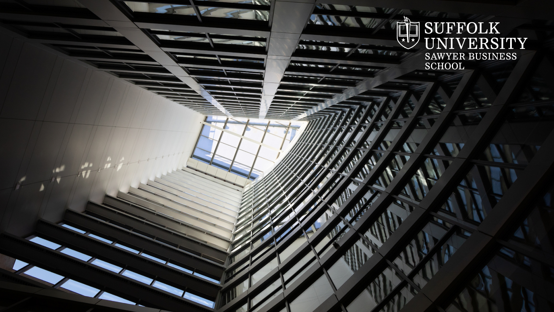 Looking upwards inside the Miller Hall atrium with  Suffolk's Sawyer Business School logo in the top corner