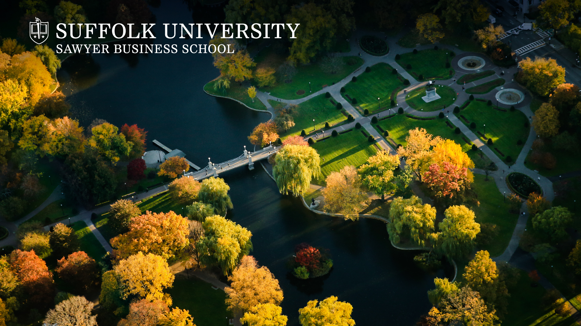 Aerial view of Boston Public Garden in the fall with  Suffolk's Sawyer Business School logo in the top corner