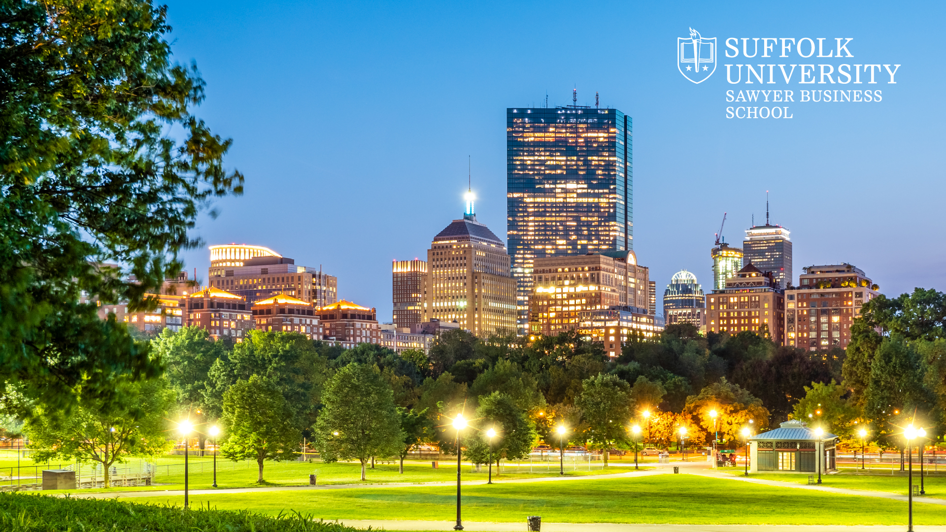 Boston Common with Back Bay in the background at twilight in the summer with  Suffolk's Sawyer Business School logo in the top corner