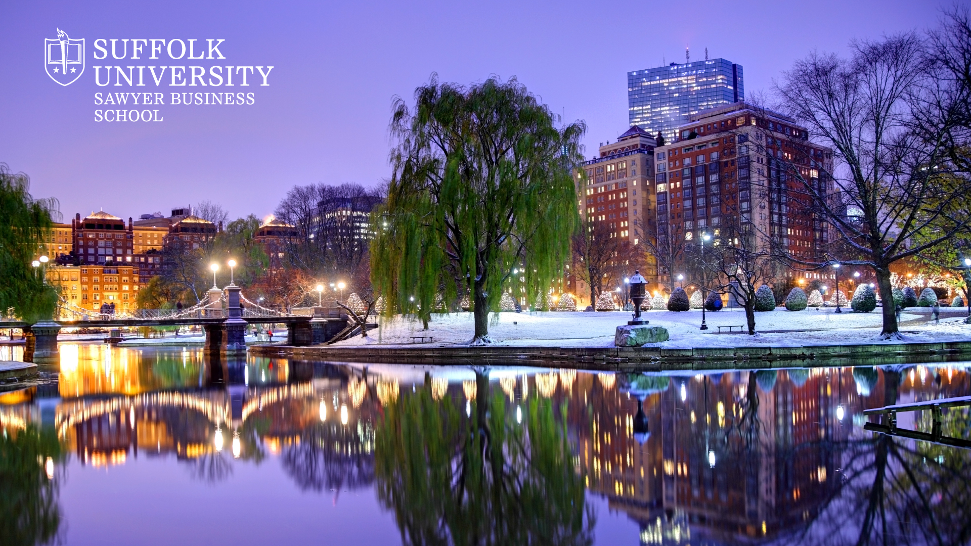 Snow blanketing Boston Public Garden at twilight  with  Suffolk's Sawyer Business School logo in the top corner
