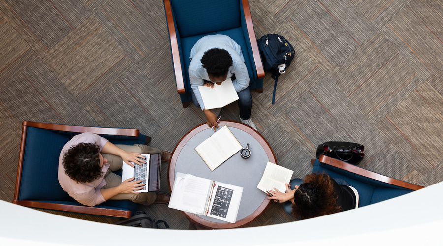 Suffolk students gathered with a professor in the Law Library in Sargent Hall.