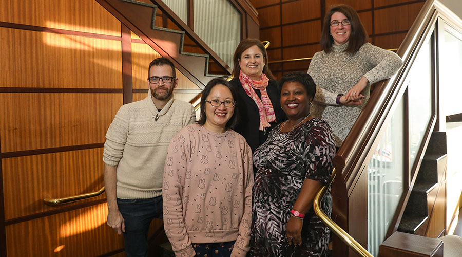 Faculty and Staff standing on staircase, smiling