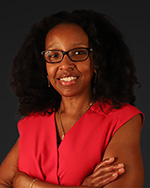 Portrait of Trustee Tamela Bailey, smiling in red dress and arms crossed