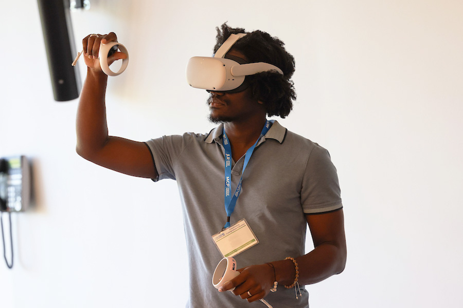 A Suffolk student interacting with the space around him while wearing a VR headset.