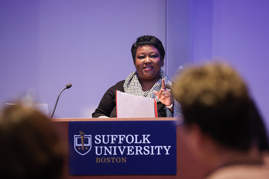 Joyya Smith standing at a podium giving a talk during an inclusion symposium.