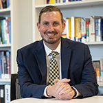 jamie bondar Portrait in front of bookshelf