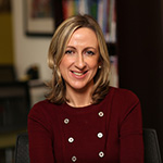 Orla Downey Portrait in front of bookshelf