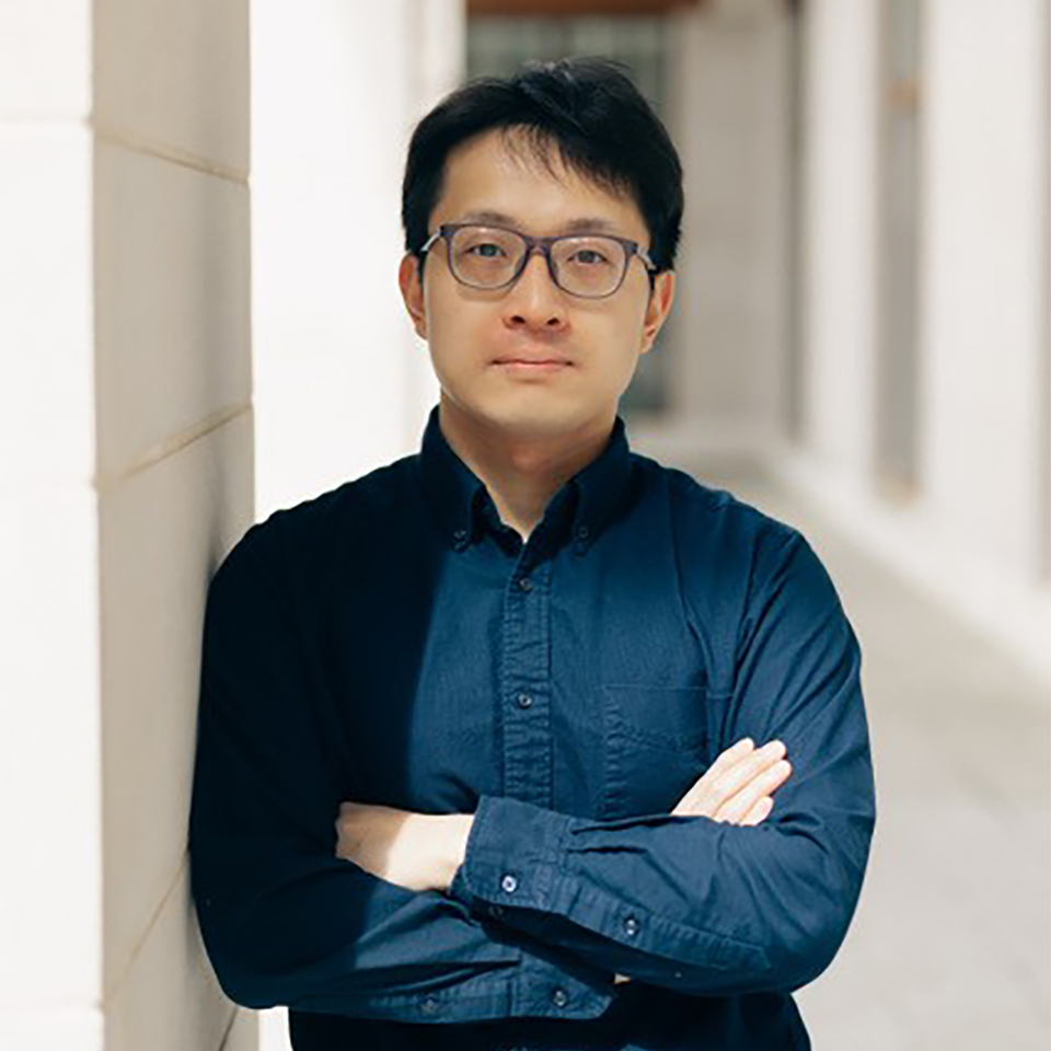 Yukai Huang blue shirt arms folded portrait photo