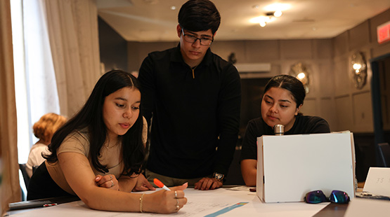 Students working in groups on pitches for summer entrepreneurship course.
