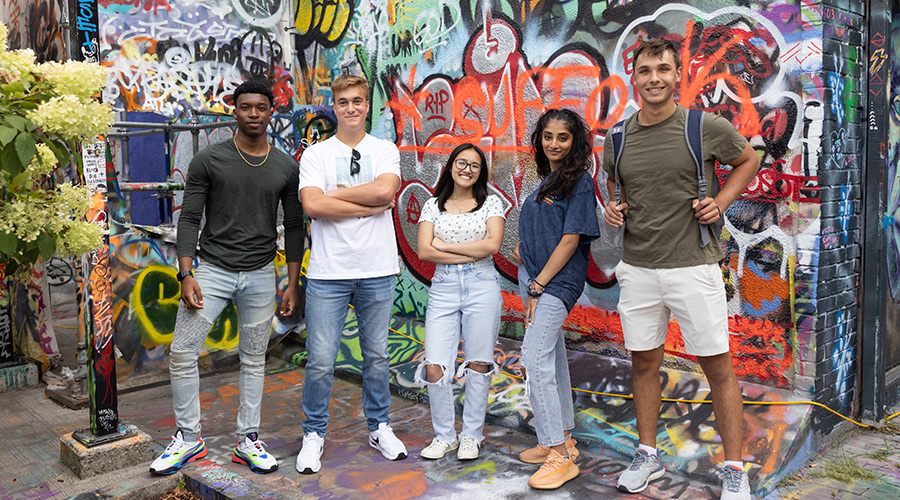 Suffolk students pose for a photo in Graffiti Alley in Cambridge.