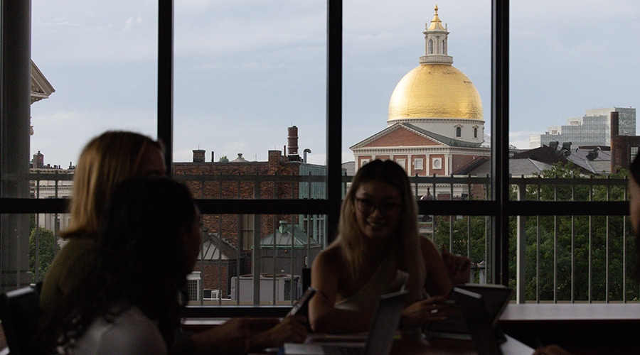Suffolk students work on a group project in a classroom overlooking the Massachusetts State House.