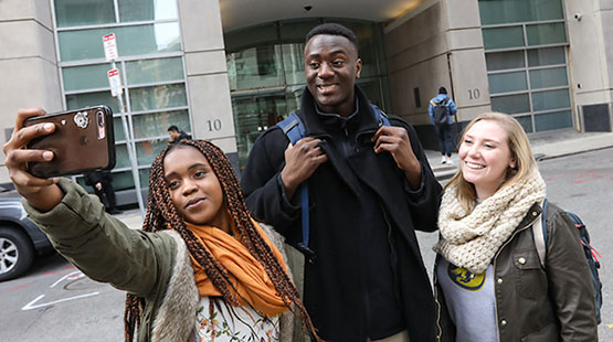New students take a group selfie in front of Miller Hall on Campus