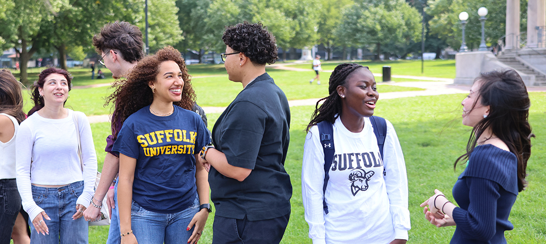 A group of Suffolk students chatting together in the Boston Common on a late Summer day.