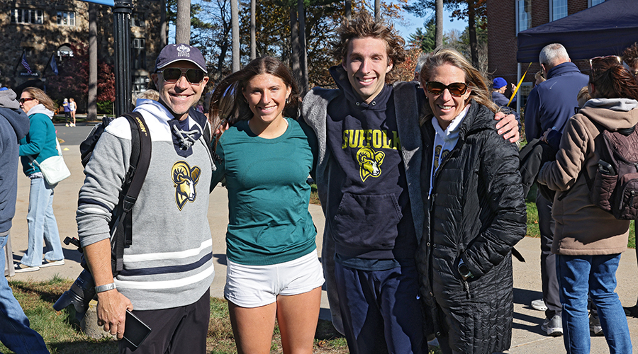 Suffolk Cross Country Team member at an away meet posing with their family.