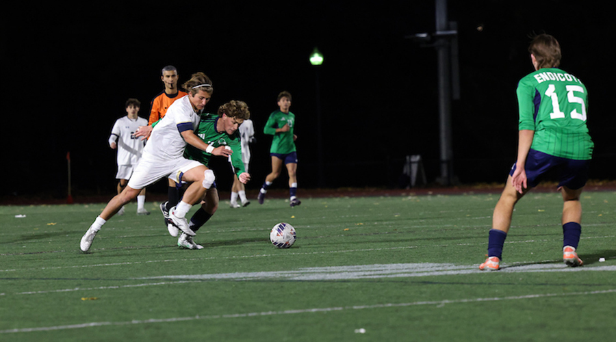 A Suffolk Men's Soccer playing angles for a shot against an opponent.