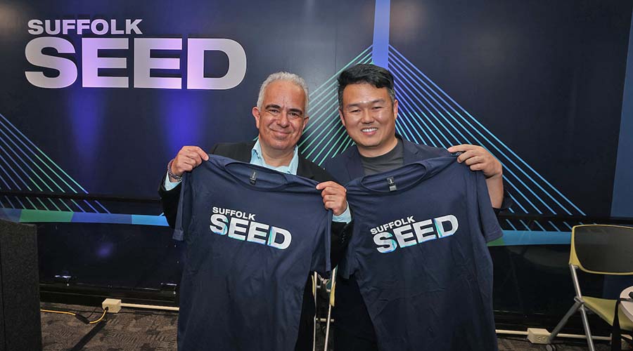 Suffolk alum Bo Zhang poses for a photo with a presenter at a SEED event
