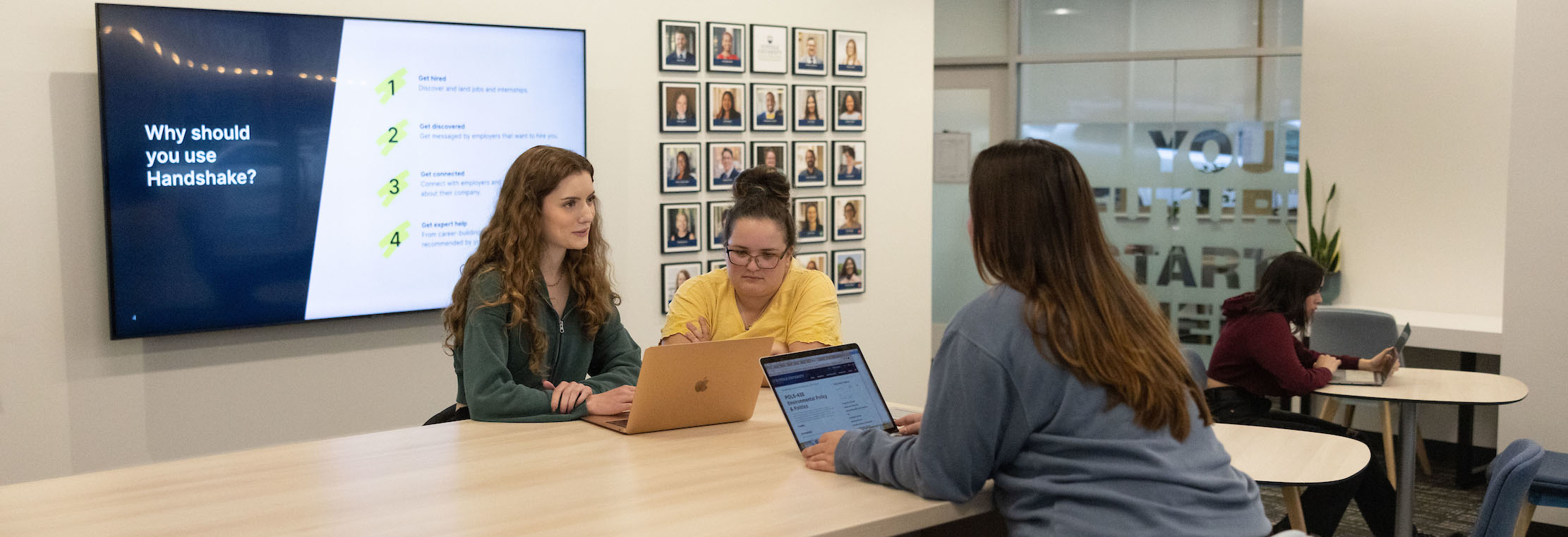 Students working together in Suffolk University's new Career Center at a high table.
