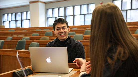 Student and alum sitting in classroom 
