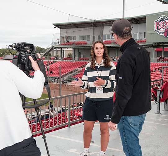 Student conducts interview at Fenway Park
