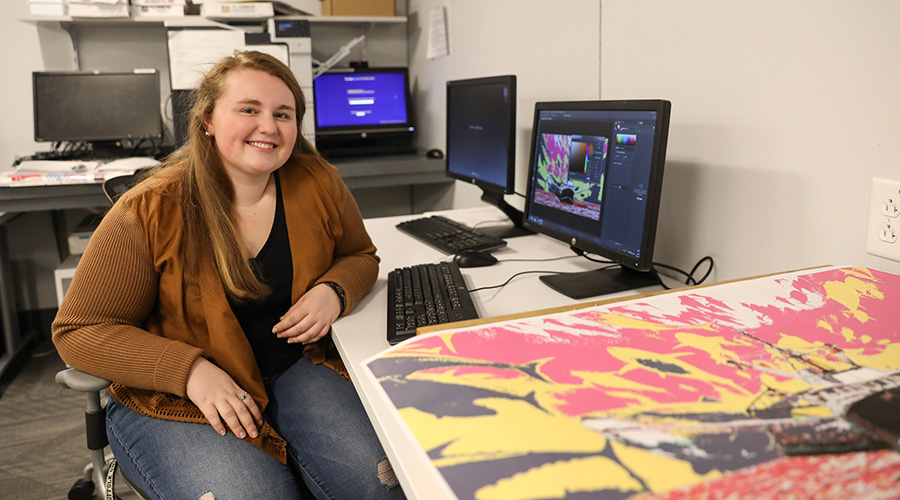 Suffolk student sitting with her artwork