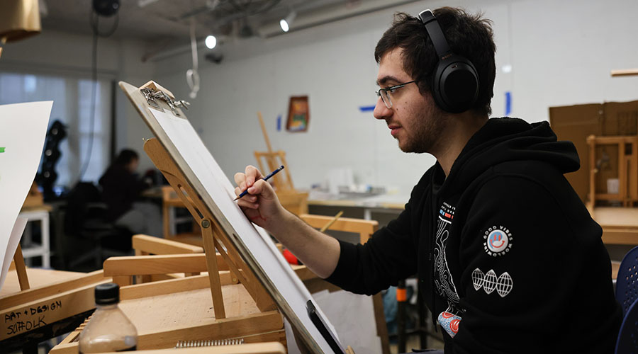 A student working at an easel in a classroom