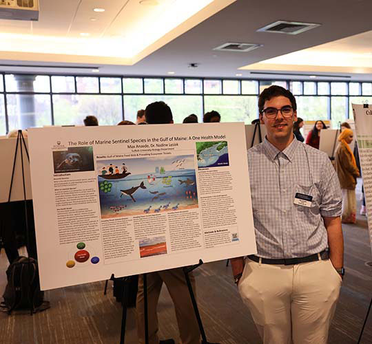 Student displays poster at a symposium