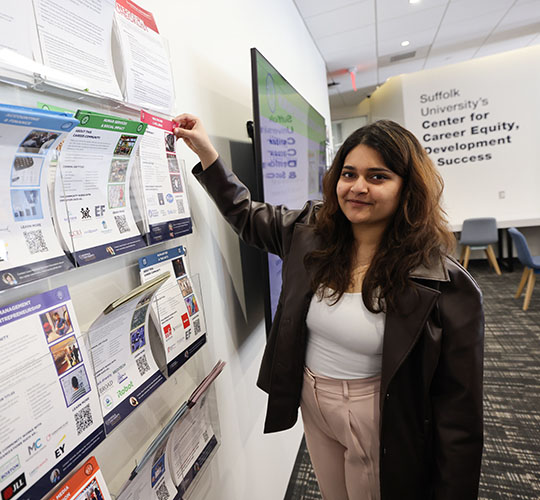 Student in The Career Center reaching for a pamphlet