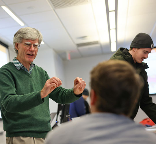 Professor engages with student during a class