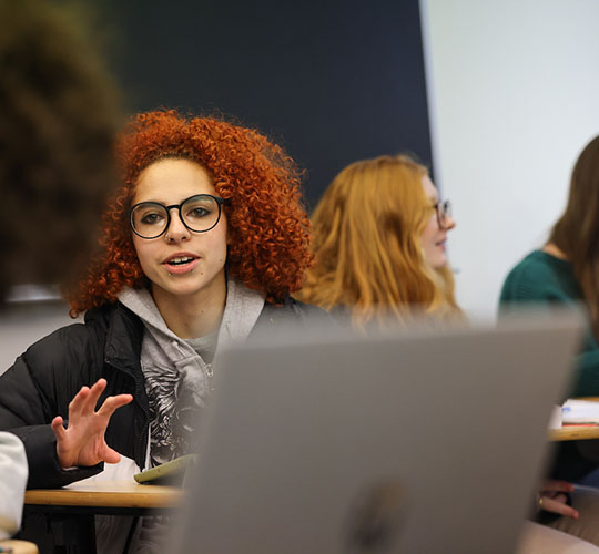 A student gestures while talking to another