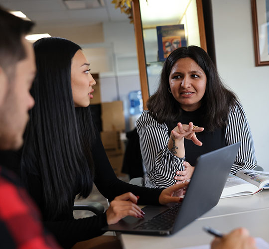 Three students at a table talking