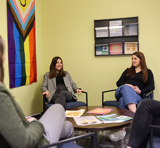 Several students sit at a table in Psychology Department office