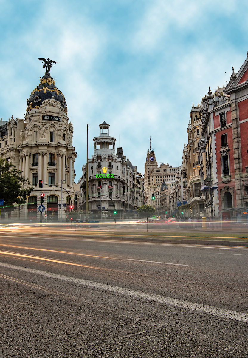 Blurred traffic passes iconic buildings in Madrid, Spain