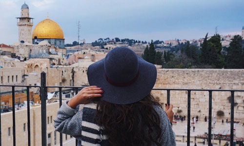 A Suffolk student looking over a balcony while studying abroad in Israel.