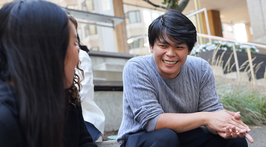 Two Suffolk students talk outside the Samia Academic Center.